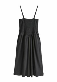 Rochie neagră cu bretele subțiri reglabile, corset cu pliuri și fustă fluidă. Confecționată dintr-un material fin, cu o croială relaxată și detalii strânse.