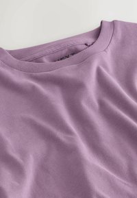 Purple cotton t-shirt featuring a crew neck design. The fabric has a smooth texture with subtle wrinkles, creating a relaxed appearance.
