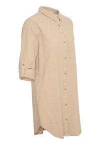 Chemise beige à boutons avec col et une poche plaquée sur la poitrine. Manches retroussées et ourlet légèrement arrondi. Confectionnée en tissu doux.