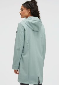 Light mint green coat with a hood, featuring a smooth texture, straight cut, and side slits. Black accent on the sleeve for detail.