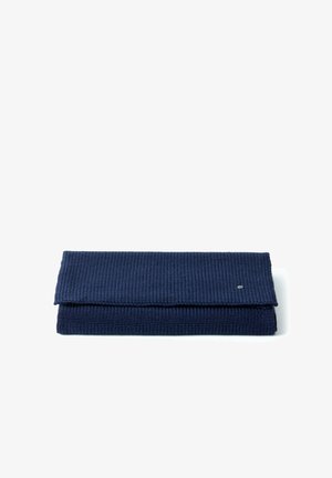 Gefalteter marineblauer gestrickter Schal mit gerippter Struktur und kleinem rundem Metall-Logo auf weißem Hintergrund.