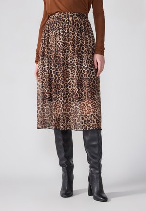 Midi sukně s leopardím vzorem vyrobená z lehké, průsvitné látky s elastickým pasem, doplněná o úzké černé kožené vysoké boty po kolena.