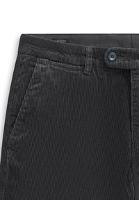 Schwarze Cordhosen mit glatter Textur, vertikaler Rippung, Knopfverschluss und Vordertaschen, mit einem Logetikett am Bund.