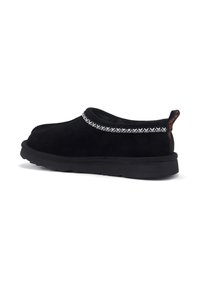 Crne nubuk cipele bez pertli s teksturiranim, pletenim srebrnim detaljem oko izreza i crnom gumenom potplatom. Imaju traku za vuču na poleđini radi lakšeg oblačenja.