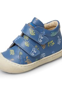 Blå barnskor med två kardborreband och färgglada djurmönster, beige sula och vadderad ankelkrage.