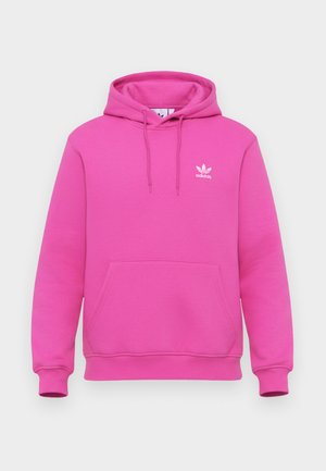 Rozā kapuces džemperis, kas izgatavots no mīksta auduma, ar kengura kabatu, saistošu kapuci un balto Adidas logotipu kreisajā krūtī.