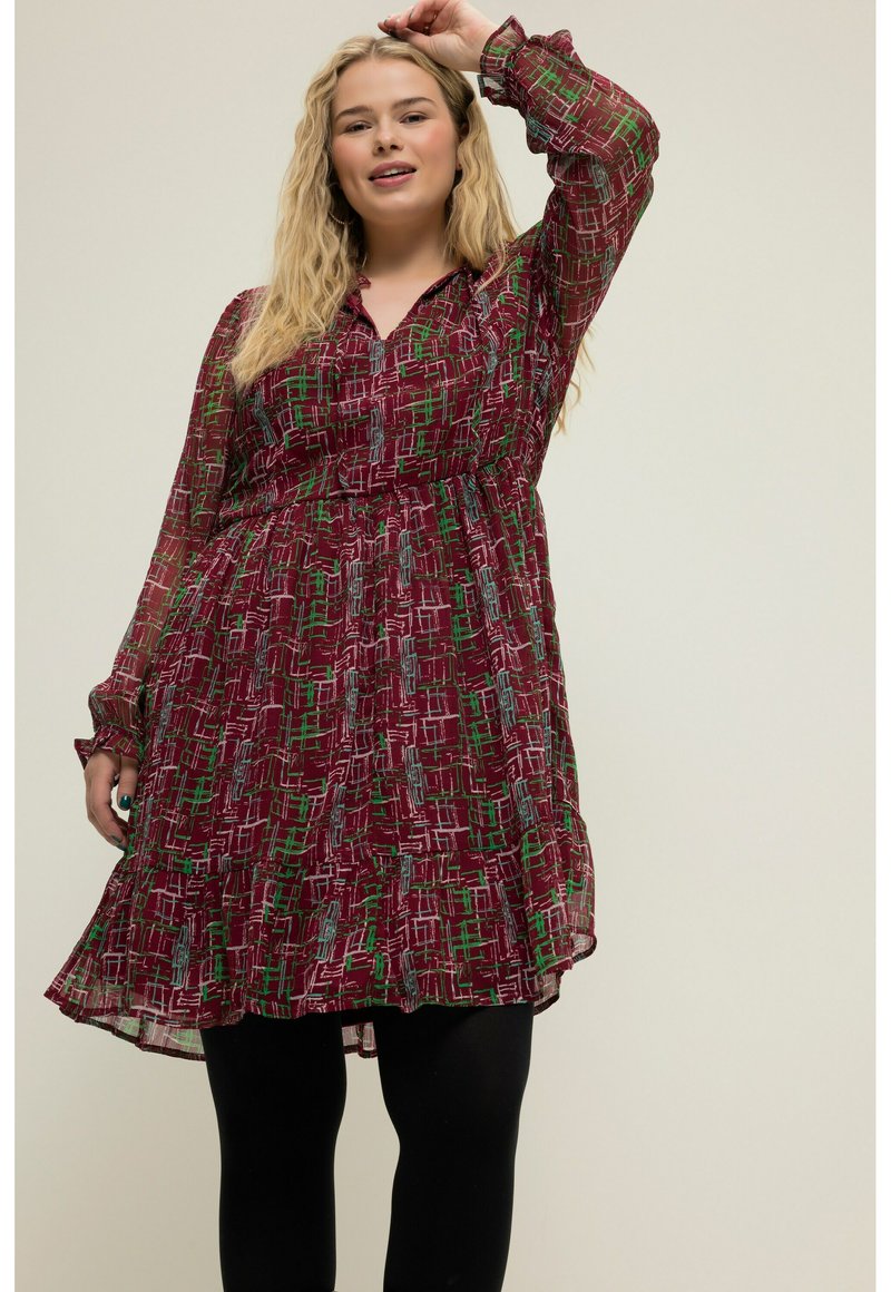 Vestido burdeos con un estampado geométrico en blanco, verde y azul. Mangas largas, cierre de botones en la parte delantera y cintura fruncida, que llega hasta medio muslo.