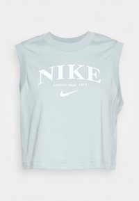 Světle modré bezramínkové krátké tričko Nike má velké bílé logo a text "Athletic dept. 1972", vyrobené z měkkého bavlněného materiálu.