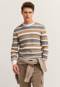 Sweter z okrągłym dekoltem w poziome paski w kolorach brązowym, białym i niebieskim. Żebrowany dekolt i mankiety. Tkanina z mieszanki bawełny, luźny krój. Starannie związany beżowy sweter w talii.