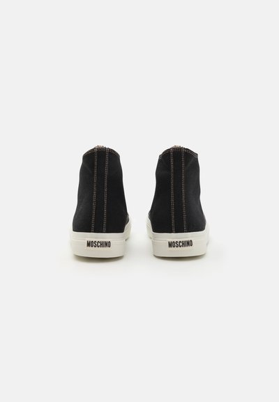 Melni augsti sporta apavi ar kontrast�ējošu beigtu šuvumu un gumijas zoli, aprīkoti ar papēža cilpu un "Moschino" logo aizmugurē.