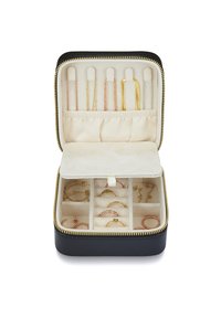 Black zippered jewelry case with cream interior. Features compartments, rings, and earring slots. Plush texture and gold zippers.