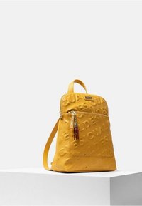 Yellow faux leather backpack with embossed logo pattern, front zip pocket featuring multicolored tassels, adjustable shoulder straps.