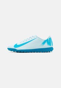 Světle modré fotbalové boty Nike s modrou podrážkou, tkaničkami a velkým logem swoosh na boku, navržené pro hru na umělé trávě.
