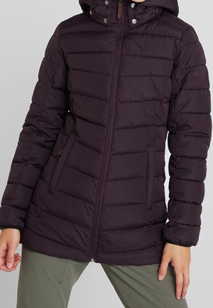 Chaqueta acolchada negra con cremallera frontal, bolsillos laterales y cuello acolchado, usada con pantalones verde oliva.