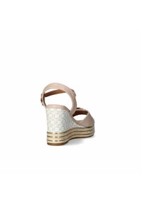 Sandalo con zeppa beige, con tomaia in pelle liscia, cinturino alla caviglia regolabile e tacco bianco decorato con motivi e dettagli dorati.