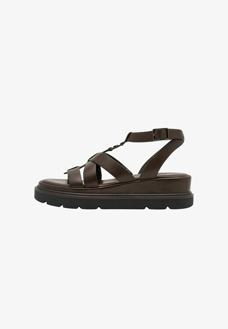 Sandales à plateforme en cuir marron avec larges brides croisées, bride de cheville ajustable et semelle en caoutchouc noir texturé.