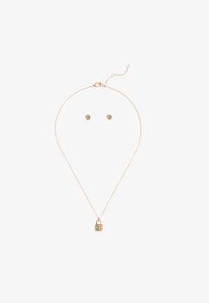 Set di gioielli dorati che include una collana con catena fine e ciondolo a forma di lucchetto, abbinata a orecchini a bottone a forma di fiore.