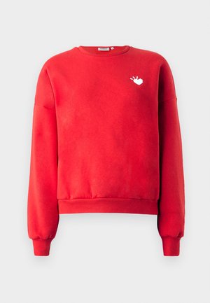 Sweatshirt rouge en tissu doux, avec un col rond, des manches longues et un graphique en forme de cœur blanc sur le côté gauche de la poitrine.