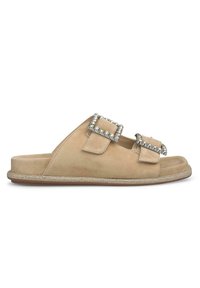 Beige Wildleder-Sandalen mit zwei mit Juwelen besetzten Schnallen und einem strukturierten Rand entlang der Sohle. Flaches Design, offen und lässig.