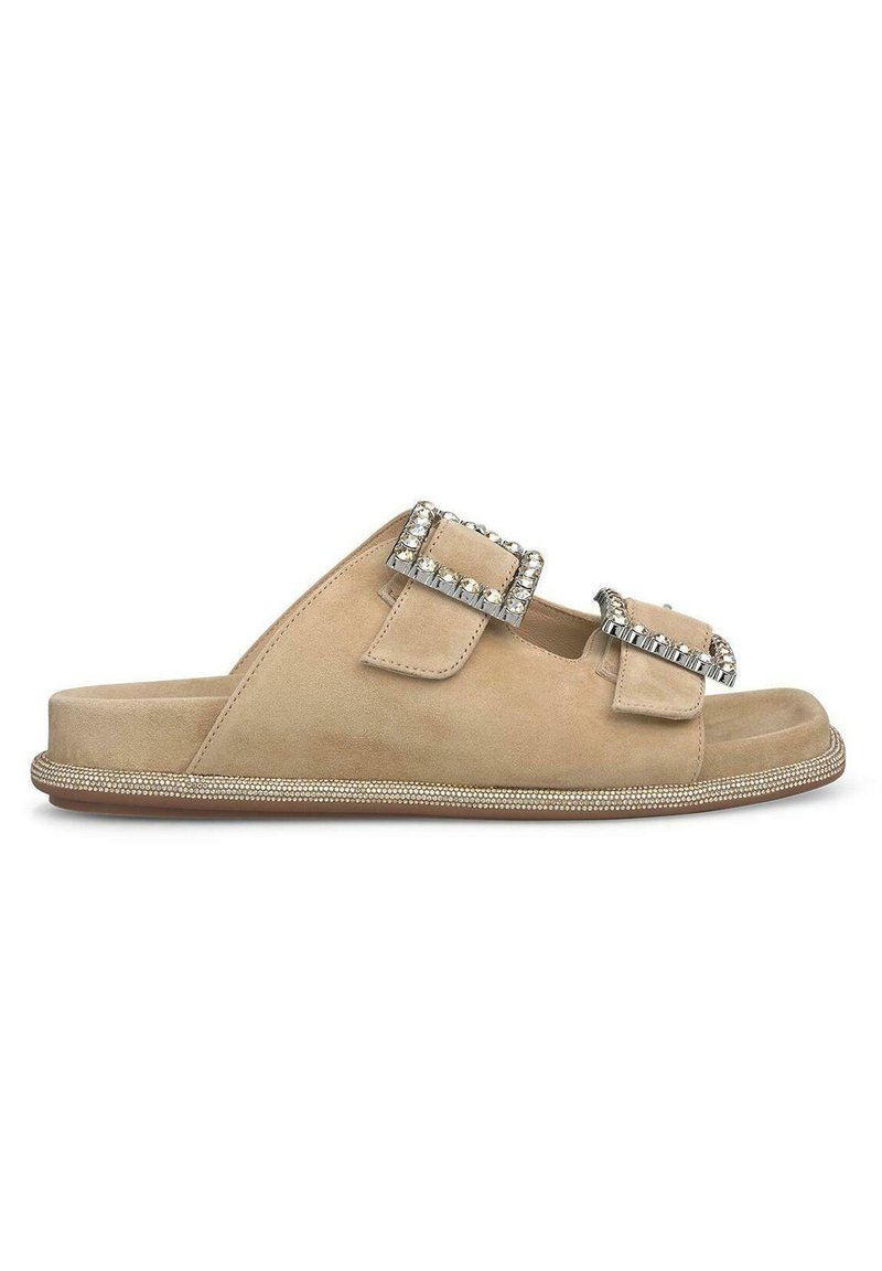 Beige Wildleder-Sandalen mit zwei mit Juwelen besetzten Schnallen und einem strukturierten Rand entlang der Sohle. Flaches Design, offen und lässig.