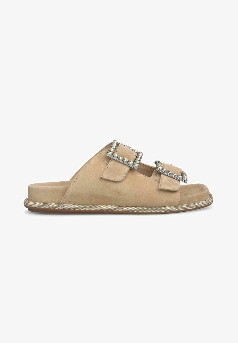 Beige suede slide sandals with two jeweled buckle accents and a textured border along the sole. Flat design, open-toe, casual style.