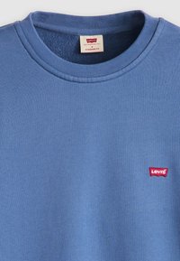 Blue cotton crew neck sweatshirt with ribbed collar, featuring a small red Levi's logo on the left chest. Standard fit, soft texture.