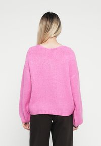 Maglione in rosa chiaro di grandi dimensioni, morbido, con scollatura tonda e maniche lunghe, dotato di un motivo testurizzato e orlo a coste.
