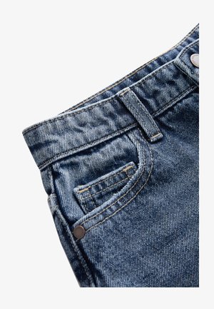 Tamsiai mėlynos spalvos džinsai su tekstūruotu paviršiumi, su priekine kišene ir kontrastingomis siūlėmis, metalinės sagos juosmens juostoje detalė.