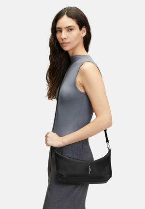 Sac à épaule en cuir noir avec un design courbé et une finition texturée, doté d'une bandoulière fine et réglable ainsi que de quincaillerie métallique.
