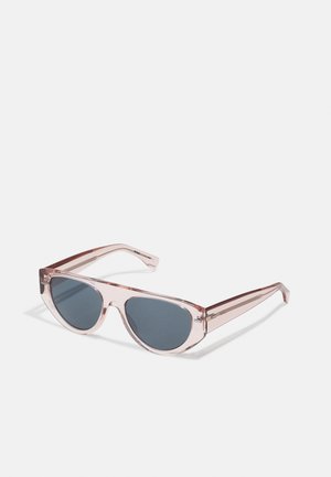 Occhiali da sole rosa trasparenti con lenti grigie scure. Design angolare con montatura spessa e aste sottili, decorate con sottili accenti metallici.