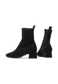 Des bottines en suède noir avec un talon bloc, une finition lisse, un bout pointu, une fermeture éclair sur le côté et une languette à l'arrière pour un enfilage facile.