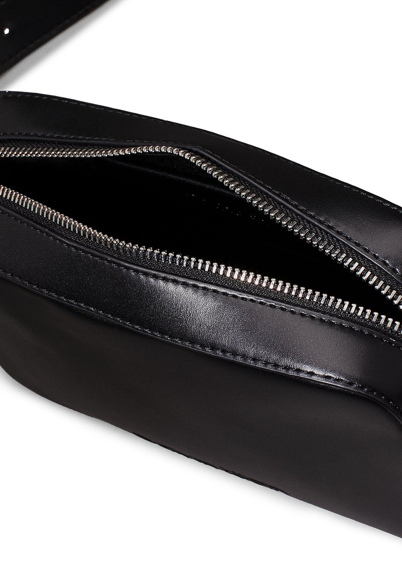 Pochette in pelle nera con una texture liscia, caratterizzata da una zip argentata e dettagli di cucitura lungo il bordo. Si apre per rivelare un interno foderato in tessuto.