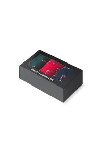 Pudełko zawierające trzy pary skarpetek: zielone, czerwone w wzór laski cukrowej i ciemnoniebieskie. Pudełko jest czarne z przezroczystą górą.