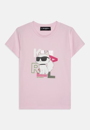 Camiseta de algodón rosa con un gato de dibujos animados que lleva gafas de sol, elementos de texto en verde, blanco y rosa, y mangas cortas.