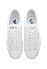 Bílé tenisky s hladkým koženým povrchem, plochými tkaničkami a značkovou stélkou se jednoduchým grafickým designem.