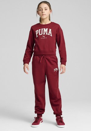 Sudadera burdeos con logotipo "PUMA", pantalones de chándal burdeos a juego con detalle del logo. Tejido de mezcla de algodón, corte relajado, puños y cintura acanalados.