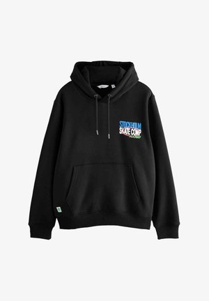 Must värvi fliisist kapuutsiga sviiter, millel on ees tasku. Rinna piirkonnas on erksam "Stockholm Skate Comp" graafika. Säädettav kapuutsi nöör.