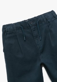Pantalones de mezcla de algodón azul marino con una cintura elástica, cordón ajustable y cierre de botón. Presenta pliegues en la parte delantera y bolsillos laterales.