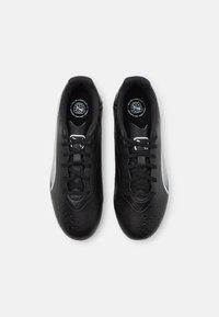 Zapatillas deportivas negras con una superficie texturizada y acentos tonales, que cuentan con una puntera redonda, diseño de cordones y detalles laterales discretos.