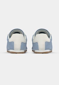 Μπλε σουέντ αθλητικά παπούτσια με λευκά δερμάτινα στοιχεία, με στρογγυλεμένη μύτη, λαστιχένια σόλα και αντίθετο ταμπελάκι στη φτέρνα. Ανθεκτική ραφή.