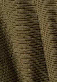 Gros plan sur un tissu tricoté vert olive côtelé montrant des motifs texturés verticaux et horizontaux détaillés.