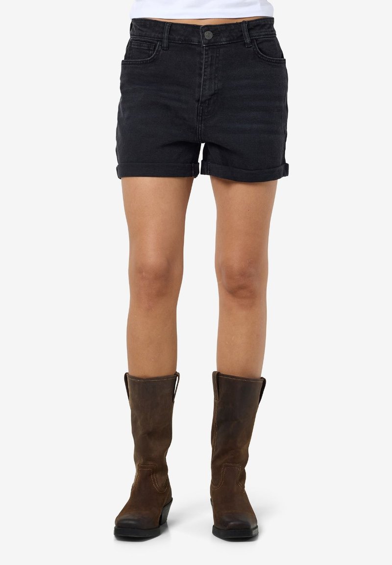 Black denim shorts with rolled cuffs, featuring a button closure and front pockets, paired with knee-high brown leather boots.