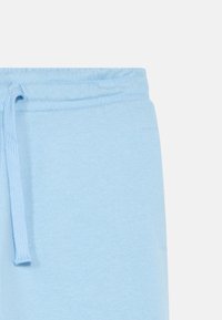 Ανοιχτό μπλε παντελόνι φόρμας με ελαστική μέση και κορδόνι. Κατασκευασμένο από μαλακό ύφασμα, με πλαϊνή τσέπη και λείο υφή.