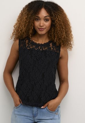 Black lace sleeveless top featuring a scalloped neckline and floral pattern, worn over light blue denim with a relaxed fit.