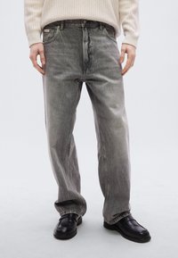 Γκρι τζιν παντελόνια από denim με άνετη εφαρμογή, ξεθωριασμένη υφή και θηλιές για ζώνη. Διαθέτουν κλασικό σχεδιασμό με πέντε τσέπες και ραφές διακόσμησης.