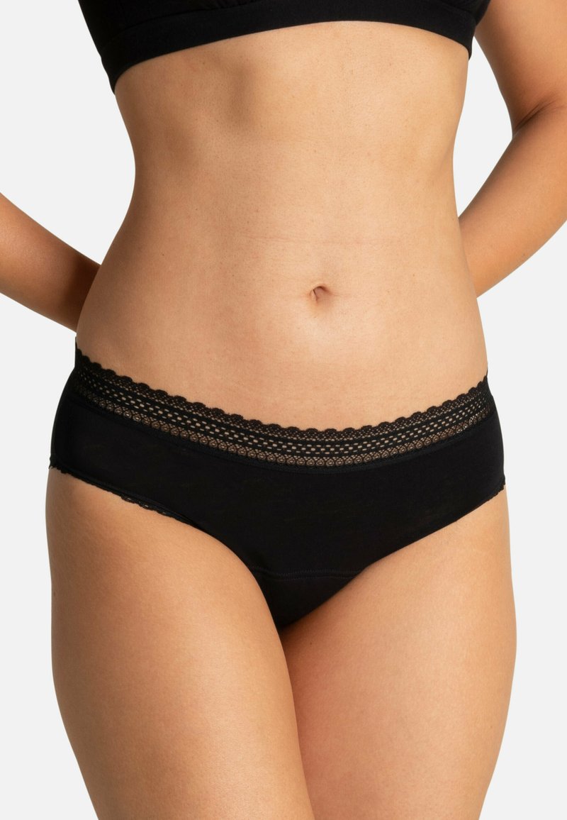 Culotte noire en coton avec une taille en dentelle festonnée. Le design présente une texture lisse et une taille basse, offrant une couverture confortable.