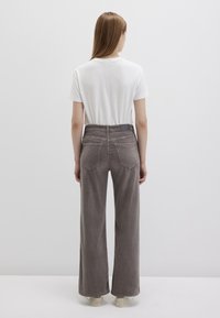 Gray corduroy wide-leg trousers with a high waist, two back pockets, and a smooth texture, paired with a plain white t-shirt.