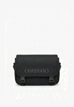 Sac bandoulière en cuir noir avec fermeture à rabat et deux sangles avant à boucle, arborant le logo embossé "CHABRAND" sur le rabat.