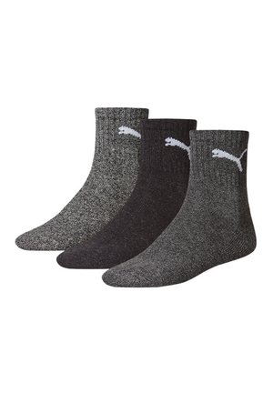 Tres pares de calcetines tobilleros en tonos de gris y negro, con textura acanalada y un logo de Puma blanco en el puño.