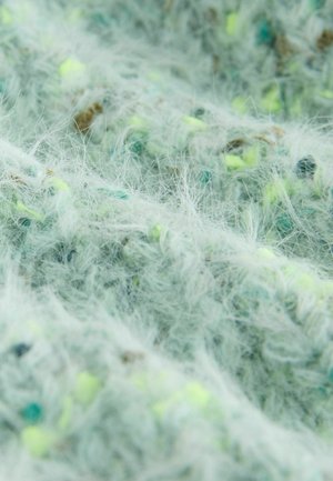 Kerge piparmündiroheline tekstuuriga kangas, millel on karvased kiud ja laialdaselt jaotunud neoonkollased ja sinised täpid, luues pehme, kihilise välimuse.